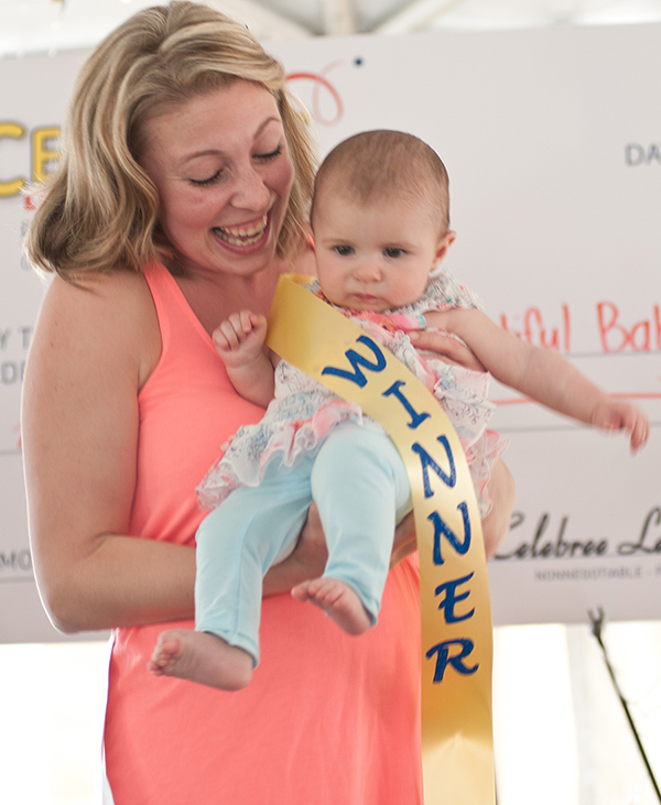 Held by her mother Heather Vogt, six month-old Charlotte Vogt accepts her title of grand prize winner in the 2015 Harford’s Most Beautiful Baby Contest (Infant).