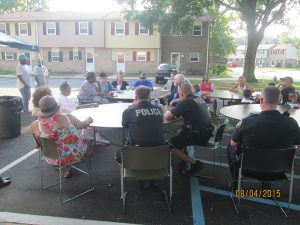Havre de Grace police officers and residents of Somerset Manor talk about community safety during National Night Out 2015, an event held around the country to build positive relationships between citizens and law enforcement.