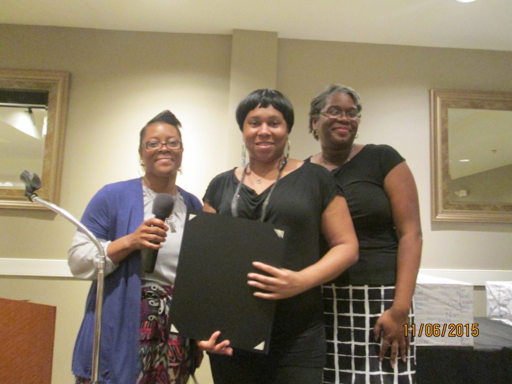Ann Chealey (left), the Family Self-Sufficiency Program Coordinator, and Nicki Biggs (right), Executive Director of The SUCCESS Project, present Sheree Sumler with a certificate of recognition.