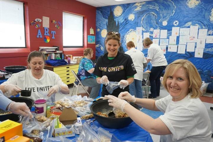 Pictured from left to right are Kattie Badders and Amber Shrodes from the Harford County Dept. of Community Services working with Joan Ingold, Dept. of Information and Communication Technology, to make trail mix included in 150 bagged lunches for the boys and girls.