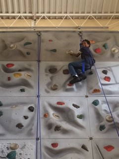 Amar Mack reaches the top of the rock wall during our field trip to the Ward Y Center  
