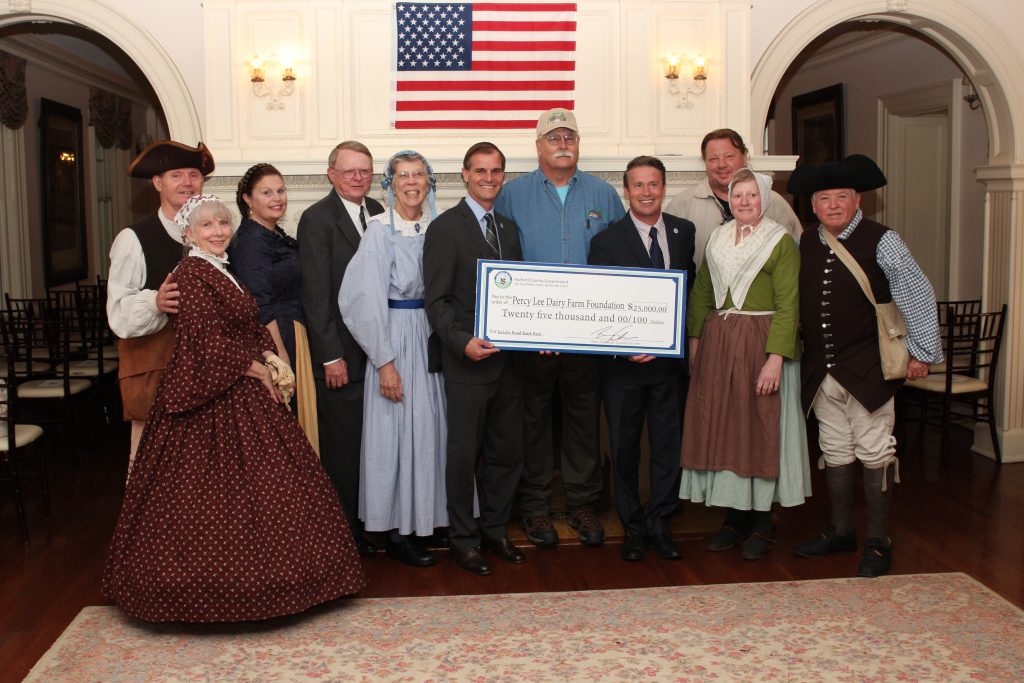 Harford County Executive Barry Glassman (center right) and Director of Administration Billy Boniface (center left) presenting a $25,000 check to representatives from the Friends of Jerusalem Mill for emergency repairs to the historic Jericho Road Bank Barn, which is being restored by the nonprofit Percy Lee Dairy Farm Foundation, Inc. 