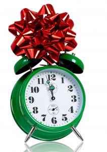 Alarm clock with red gift bow. Time for the holiday's concept with clock and present isolated on white background.