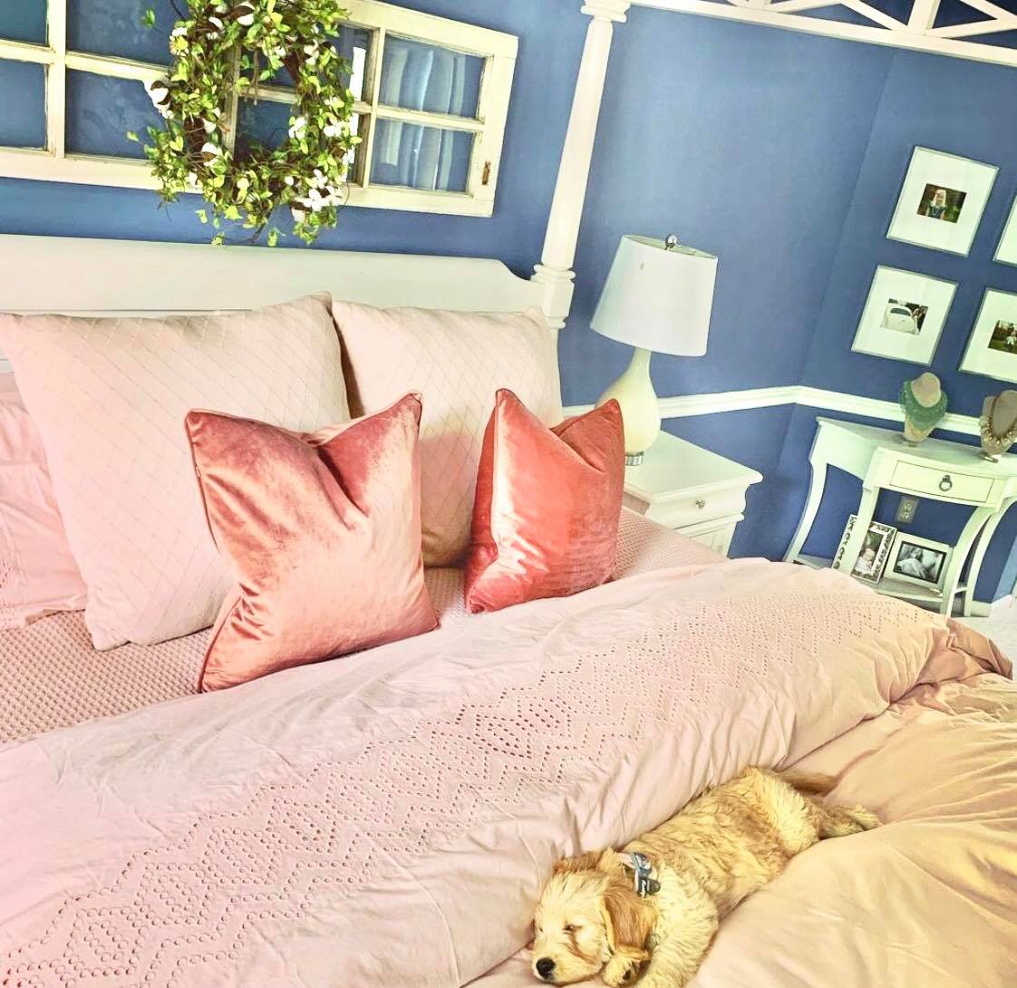 clean bed with pink comforter and pillows