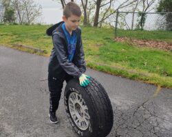 Everest Flanagan: Everest Flanagan, a River Sweep volunteer at Perryville Community Park, removes a tire found during the shoreline cleanup April 20. (Photo by Vesta Flanagan)
