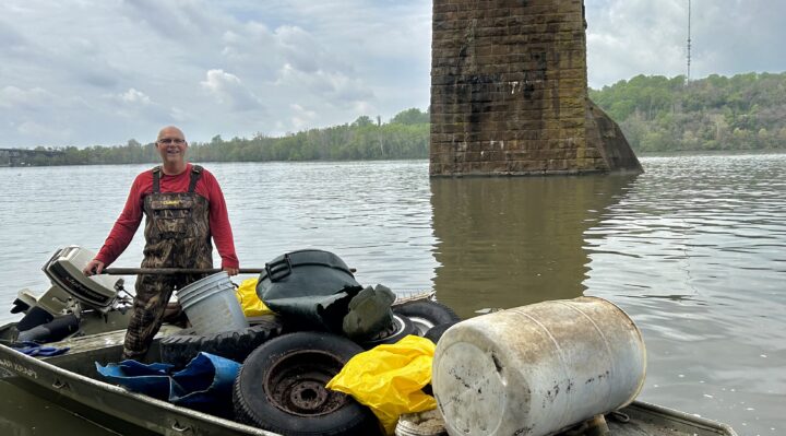 George Johnson: River Sweep volunteer George Johnson, on the west side of Garrett Island under the CSX railroad bridge, helps to collect trash and debris at the shoreline cleanup on April 20. (Photo by Bryon Bodt)